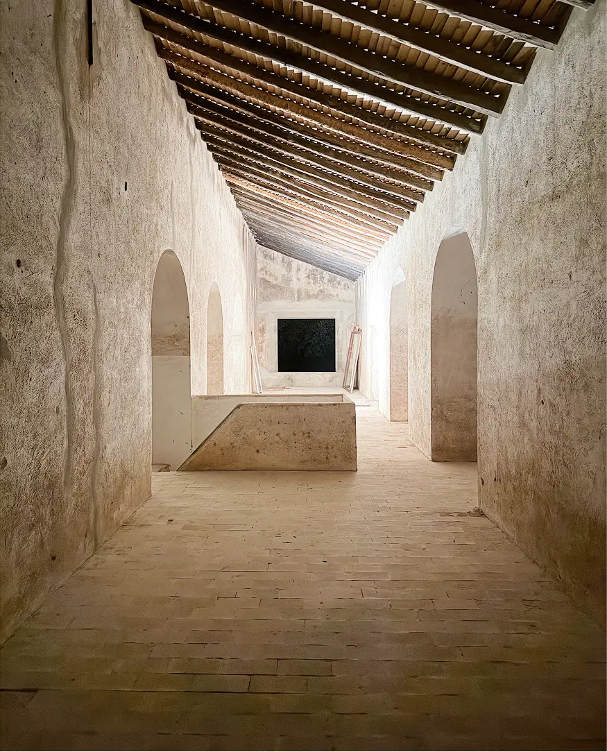 Interior de una casa de estilo rústico con paredes de piedra y techos de madera.
